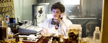 David auf einem Mobiltelefon mit Kopfhörern um seinen Hals