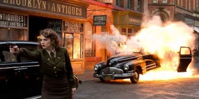 Peggy Carter Aiming Her Gun With A Car Explosion In The Background